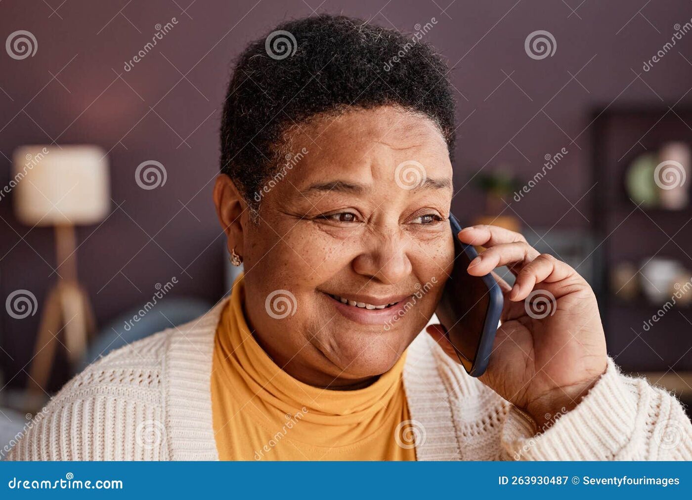 A New Orleans neighbor smiling on a phone call at home